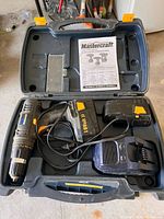 Open carry case with drill, battery, charger, manual visible