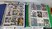 Two binders open to 9-pocket pages showing assorted hockey cards