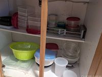Cabinet shelves showing full assortment of containers, bowls and lids