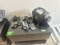 Overall lot view showing camcorder, bag, batteries, charger, remote, cables, MiniDV tapes