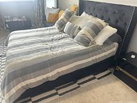 Queen bed frame with mattress, tufted headboard, side rails visible