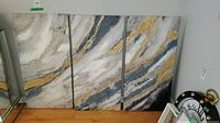 Full view of the three abstract canvas panels standing side by side