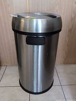 Front view of stainless steel trash bin showing cylindrical shape, side handle, base
