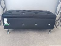 Front view of black faux leather storage ottoman