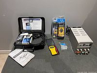 Overview of all equipment: kilogaussmeter in case, bench power supply, multimeters, leads, plugs, manuals