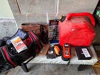 All items on bench: fuel can, Zippo kit, laser measurer, tool belt, KnotBone kit, tool bag