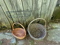 Black metal wire hanging planter frame and two wicker baskets