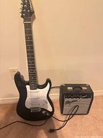 Full view of Silvertone guitar and Squier amp with cable