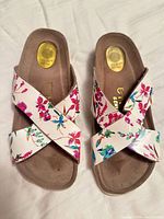 Top view showing crossed floral uppers and footbeds