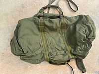 Front of olive drab nylon backpack showing compression straps
