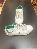 Pair of white Lacoste sneakers showing top and side views