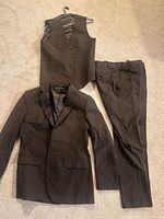 Jacket, vest on hanger, trousers laid out