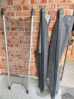 Cargo net divider and two retractable covers standing against brick wall