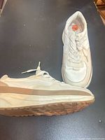 Side view of both sneakers showing uppers and sole wear