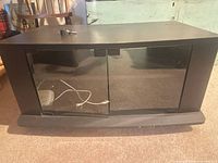 Front view of black MDF TV stand with glass doors closed