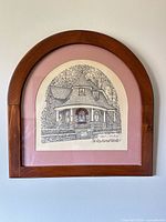 Full view of framed print showing arched wood frame, pink mat and artwork