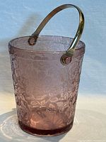 Full view of etched light purple glass ice bucket with handle upright
