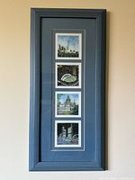 Full view of the vertical blue-framed artwork with four stacked prints