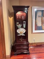Front view of cabinet showing glass door, interior shelves, drawers
