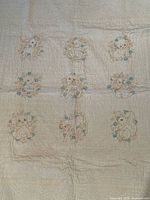 Front of quilt showing embroidered animal blocks and overall condition