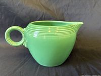 Left side view of light green Fiesta jug showing ring handle and spout