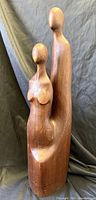 Front view of carved wood sculpture showing two abstract figures