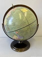 Front view of globe showing meridian, stand, and cartography