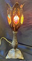Full view of ornate metal lamp illuminated