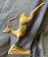 Front view of brass leaping gazelle statue on base