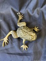 Top view of brass frog showing full body and articulation
