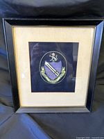 Front view of black frame showing embroidered crest patch