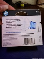 Back of HP 65 cartridge box showing recycled content, UPC, Malaysia origin, April 2026 date