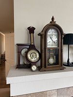 Group view showing wall clock, mantel clock and banjo barometer
