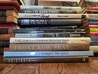 Stack of 11 hardcover books showing spines and titles