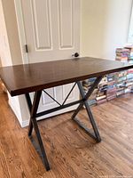 Full view of table front showing wood top and metal X-legs