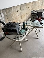 Dayton battery charger, small green motor tool, hydraulic bottle jack, EICO power supply, red drill shown on two tables