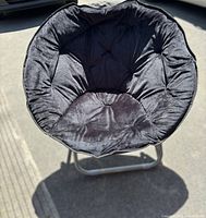 Front view of black plush saucer chair open on metal frame