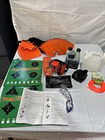 Full layout of trimmer accessories including guards, oil, fuel container, toolkit, earmuff, trimmer line, manual and goggles