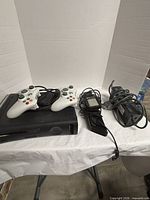 Console, two controllers, power brick and cord laid out on table