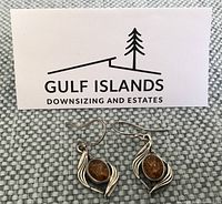 Front view of both earrings showing amber stones and silver swirl frames
