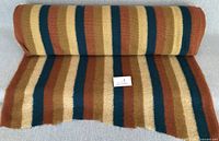 Roll of striped wool-blend fabric partly unrolled