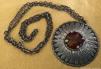 Front view of pewter pendant with amber cabochon on chain