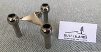 Front angle of single chrome Nagel modular candlestick holder next to business card
