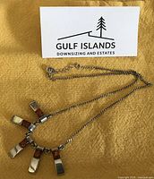 Full view of sterling necklace showing amber-inlaid pendant drops and chain