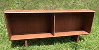 Front view of teak veneered hutch showing open compartments and legs