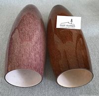 Two plated glass pendant globes lying side by side showing base openings
