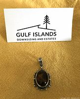 Front view of silver pendant with amber stone