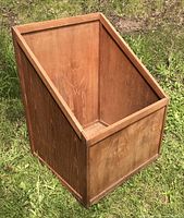Front angled view of teak storage box showing slanted opening and wood grain