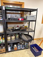 Front view of full black metal shelving unit with four shelves