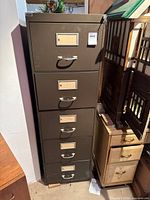 Full view of closed cabinet showing five drawers, label frames and handles